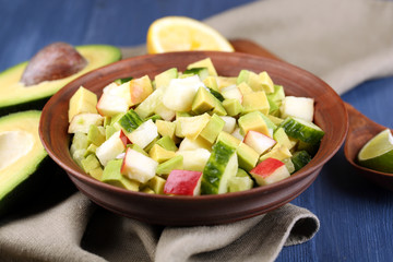 Salad with apple and avocado in bowl with napkin