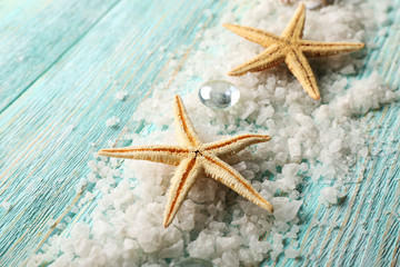 Fototapeta na wymiar Sea stars on sea salt on wooden background