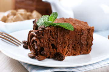 Tasty piece of chocolate cake with mint and coffee beans