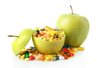 Apples and colorful pills, isolated on white