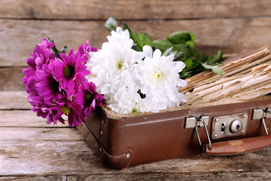 Old wooden suitcase with old books and flowers