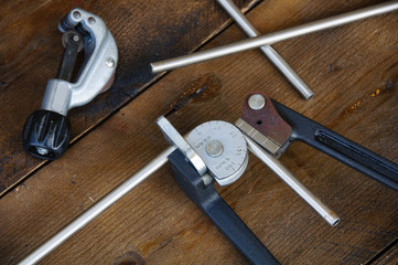 Tube bender or pipe bender tools on wooden background.