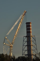 Power plant. Crane at a construction site. Chimney and smoke