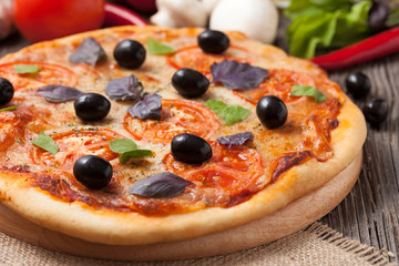 Pizza margherita with mozzarella, olive oil and basil close up