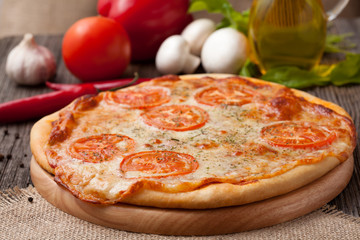 Pizza margherita with tomatoes, olive oil, pepper and garlic on
