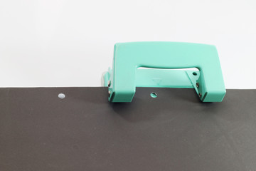 Hole puncher and blank paper on white