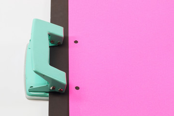 Hole puncher and blank paper on white