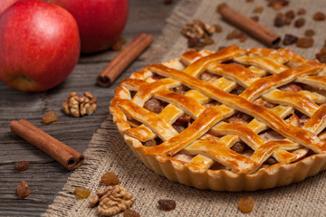 Apple pie with cinnamon on retro wooden background texture