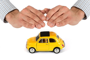 Hands Providing Protection Over Yellow Toy Car