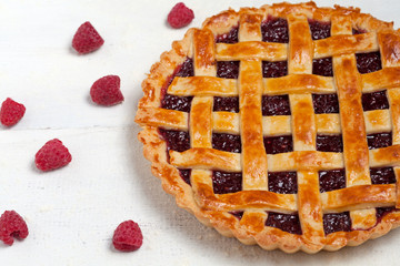 Raspberry pie with sweet sugared raspberries on white table