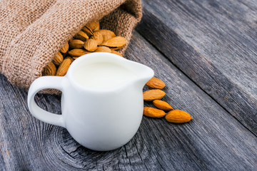 Almonds  and milk on rustic wooden background.