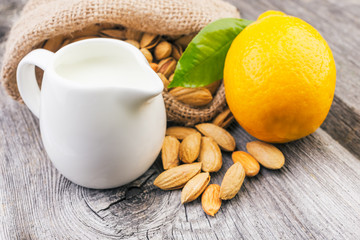 Almonds and lemon on rustic wooden background.