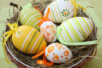 dekoratives Osternest mit bunt bemalten Eiern