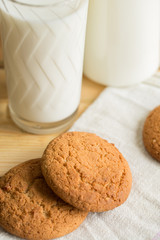 Cookies on a plate lying and standing next to a glass of milk