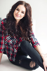 Young attractive woman in squared shirt posing in studio. Casual