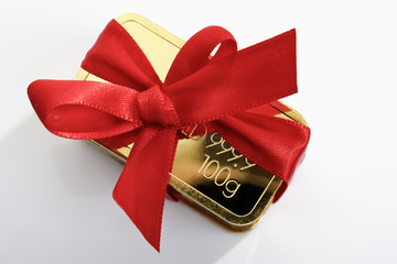 Goldbarren  mit roter Geschenkschleife