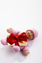 Goldbarren  mit roter Geschenkschleife auf Baby Puppe