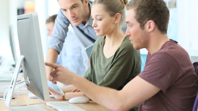 Teacher helping students in digital design