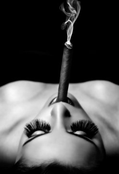 beautiful woman smokes a cigar