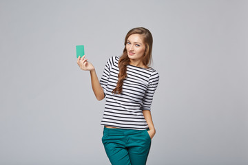 Happy smiling girl in casual clothing, showing blank credit card