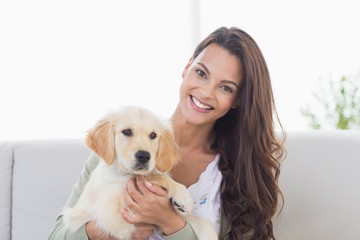 Happy young woman playing with puppy