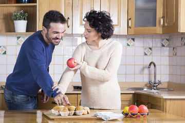 Man taking delicious cupcake while her woman offering him apple