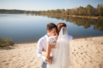Fototapeta na wymiar bride and groom, kissing on a beach