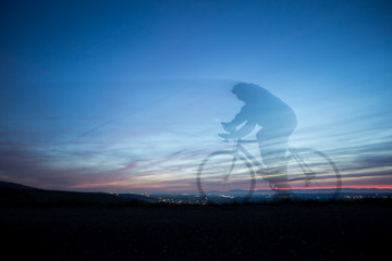 cyclist in motion blur in blue sky