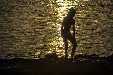 Niña pescando al atardecer – Young girl fishing at sunset