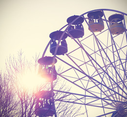 Retro vintage filtered picture of a ferris wheel at sunset.