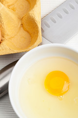 Raw egg in a white bowl.