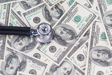 Stethoscope on one hundred US dollar bills.