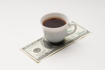 Coffee cup and one hundred U.S. dollars close-up shot