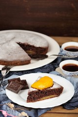Chocolate cake with mango and black tea on blue cloth with space