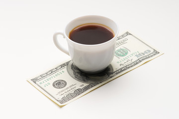 Coffee cup and one hundred U.S. dollars close-up shot