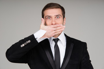 Business man making the speak no evil gesture. Businessman cover