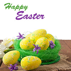 Easter eggs and flowers on wooden background