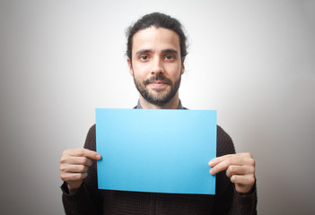 Young casual man holding a blue sign