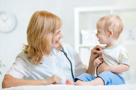 doctor examining heartbeat of kid boy with stethoscope