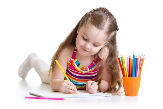 Happy little girl drawing with pencils in preschool