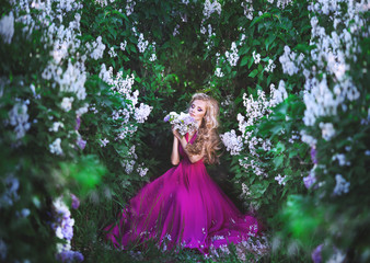 Obraz na płótnie Canvas Beautiful girl in lilac dress in flower garden