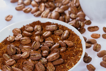 Kaffeebohnen auf Kaffeepulver mit Tasse