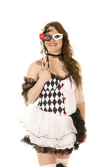 woman in a black and white costume holding mask to face