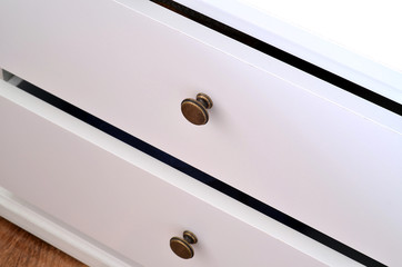 Detail of white laminated drawer with brass handle