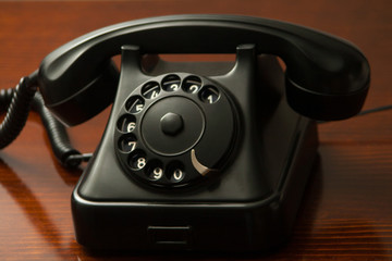 Old retro black telephone on desk