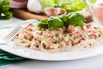 Spaghetti carbonara with bacon and basil