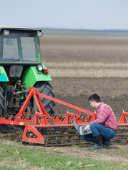 Farmer with laptop and tractor