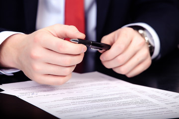 Businessman in red tie doubts sign a contract
