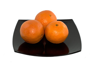 three oranges on a black plate