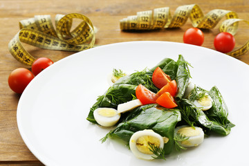 Salad with quail egg and basil in plate
